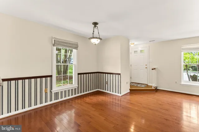 a view of a room with wooden floor windows and a chandelier fan