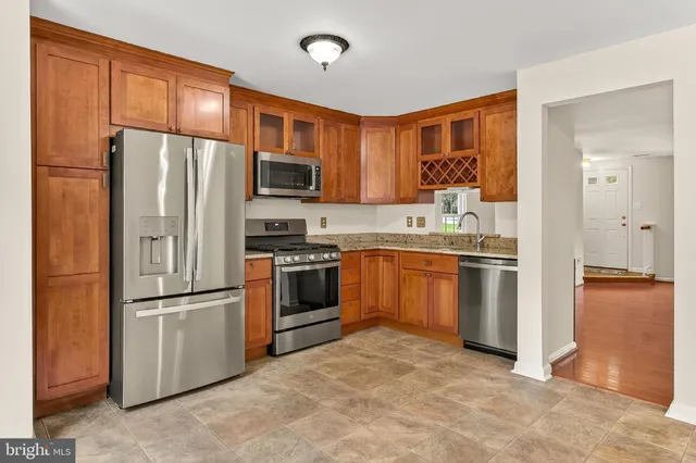 a kitchen with stainless steel appliances granite countertop a refrigerator stove and sink
