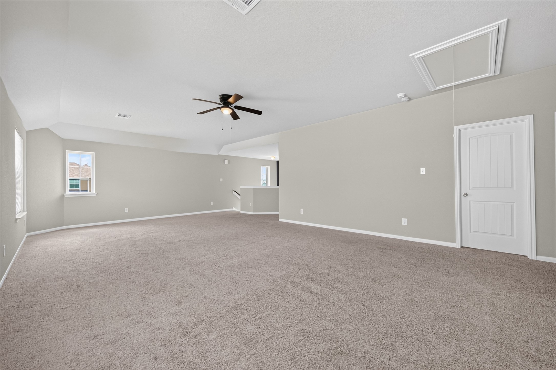 2526 Sturgeon Way Conroe, TX 77384 - Photo 29 of 49 This spacious room features a neutral color palette with plush carpeting, a ceiling fan, and ample natural light from multiple windows. Ideal for a versatile living area or large bedroom.