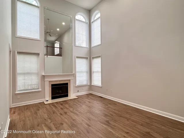 a view of empty room with wooden floor and fireplace