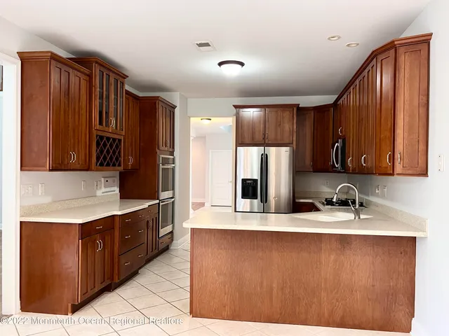 a kitchen with stainless steel appliances granite countertop a sink refrigerator and cabinets