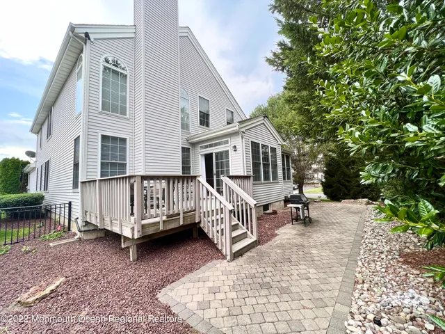 a view of a house with a wooden deck and furniture