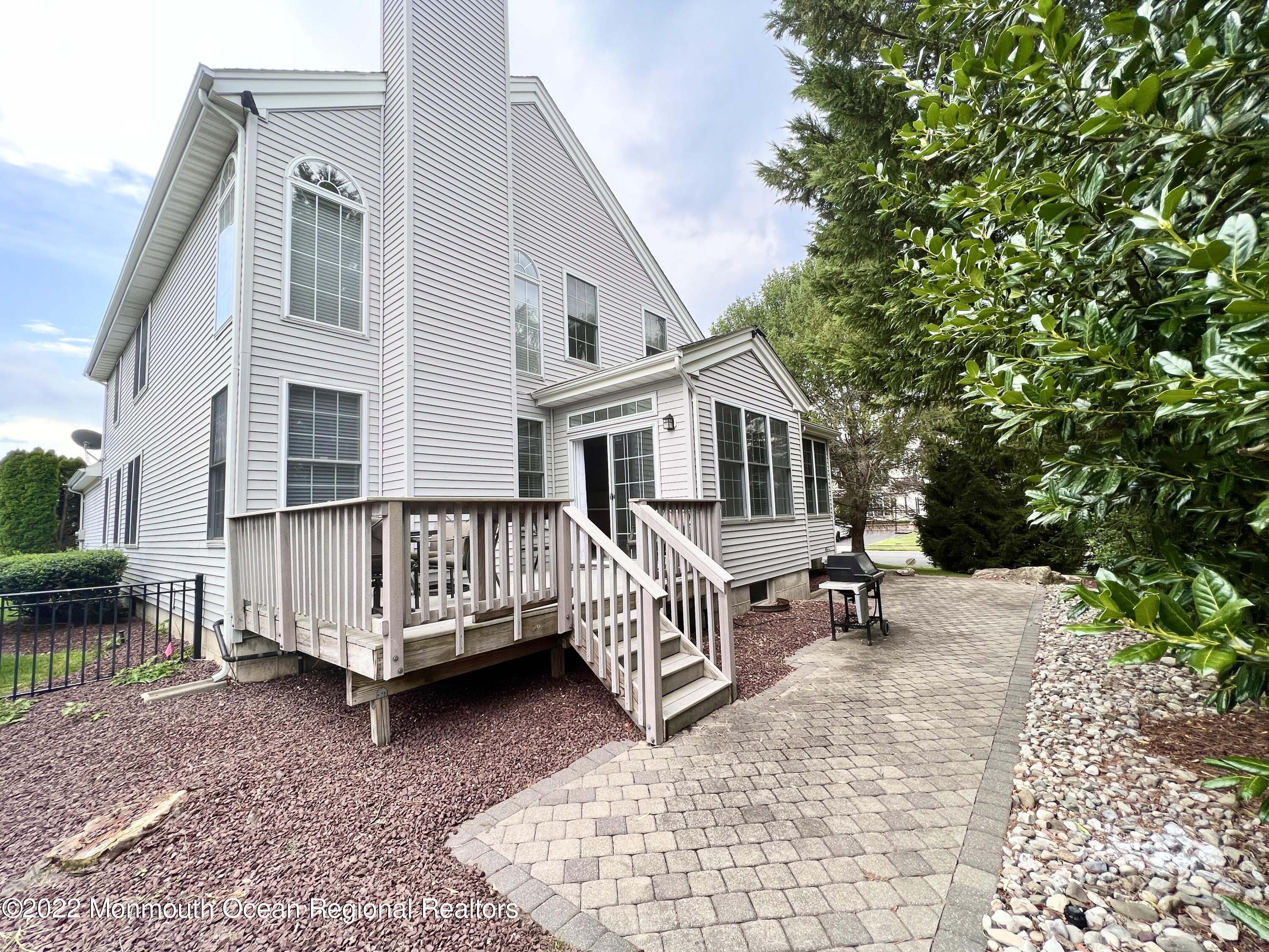 1 Hendrickson Court Manalapan, NJ 07726 - Photo 2 of 39 a view of a house with a wooden deck and furniture
