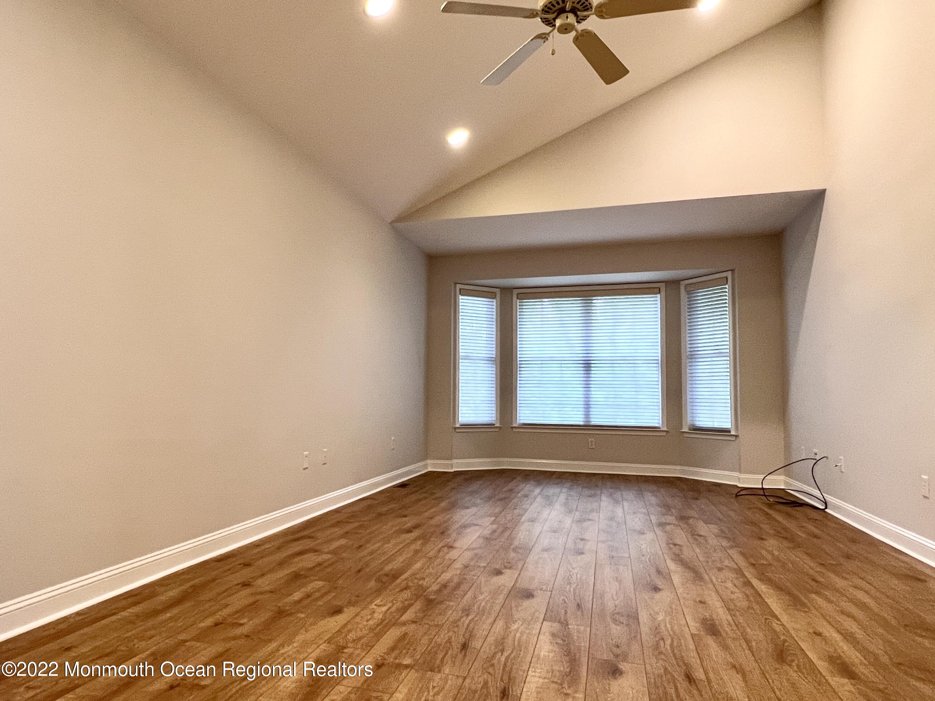 1 Hendrickson Court Manalapan, NJ 07726 - Photo 26 of 39 an empty room with wooden floor and windows