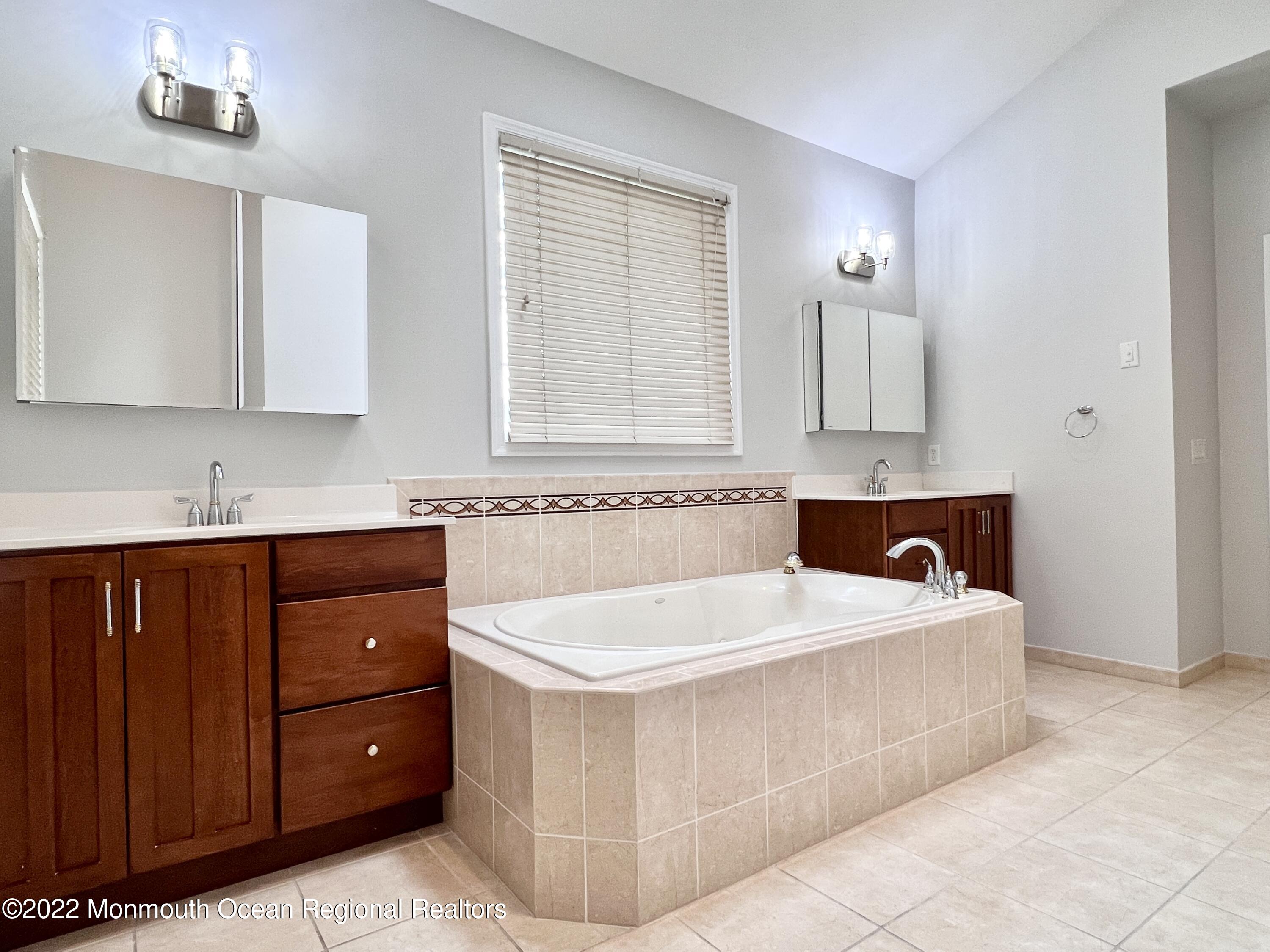 1 Hendrickson Court Manalapan, NJ 07726 - Photo 28 of 39 a spacious bathroom with a tub sink and mirror