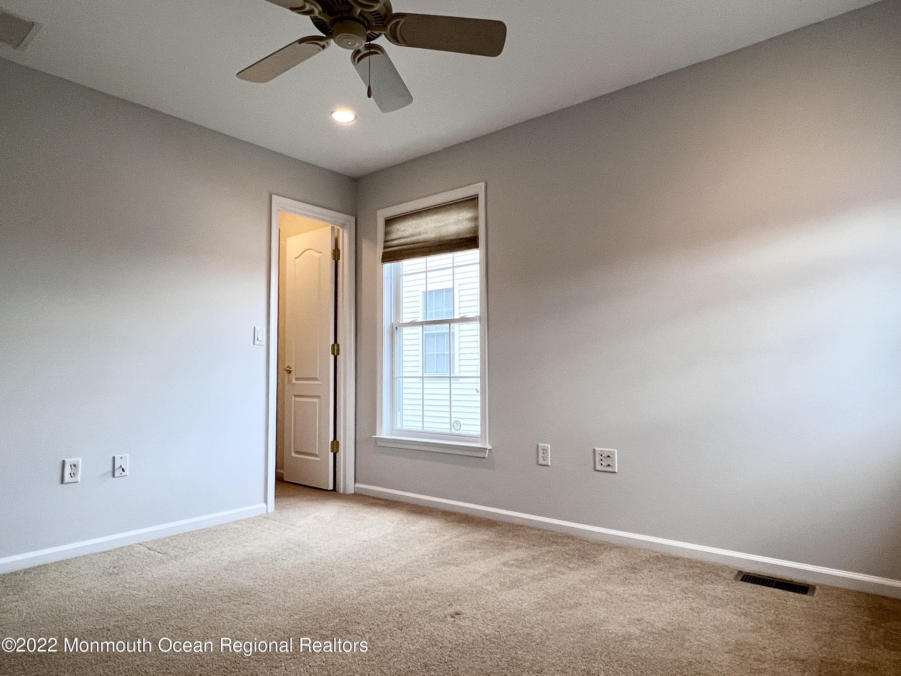 1 Hendrickson Court Manalapan, NJ 07726 - Photo 32 of 39 an empty room with a window and a ceiling fan