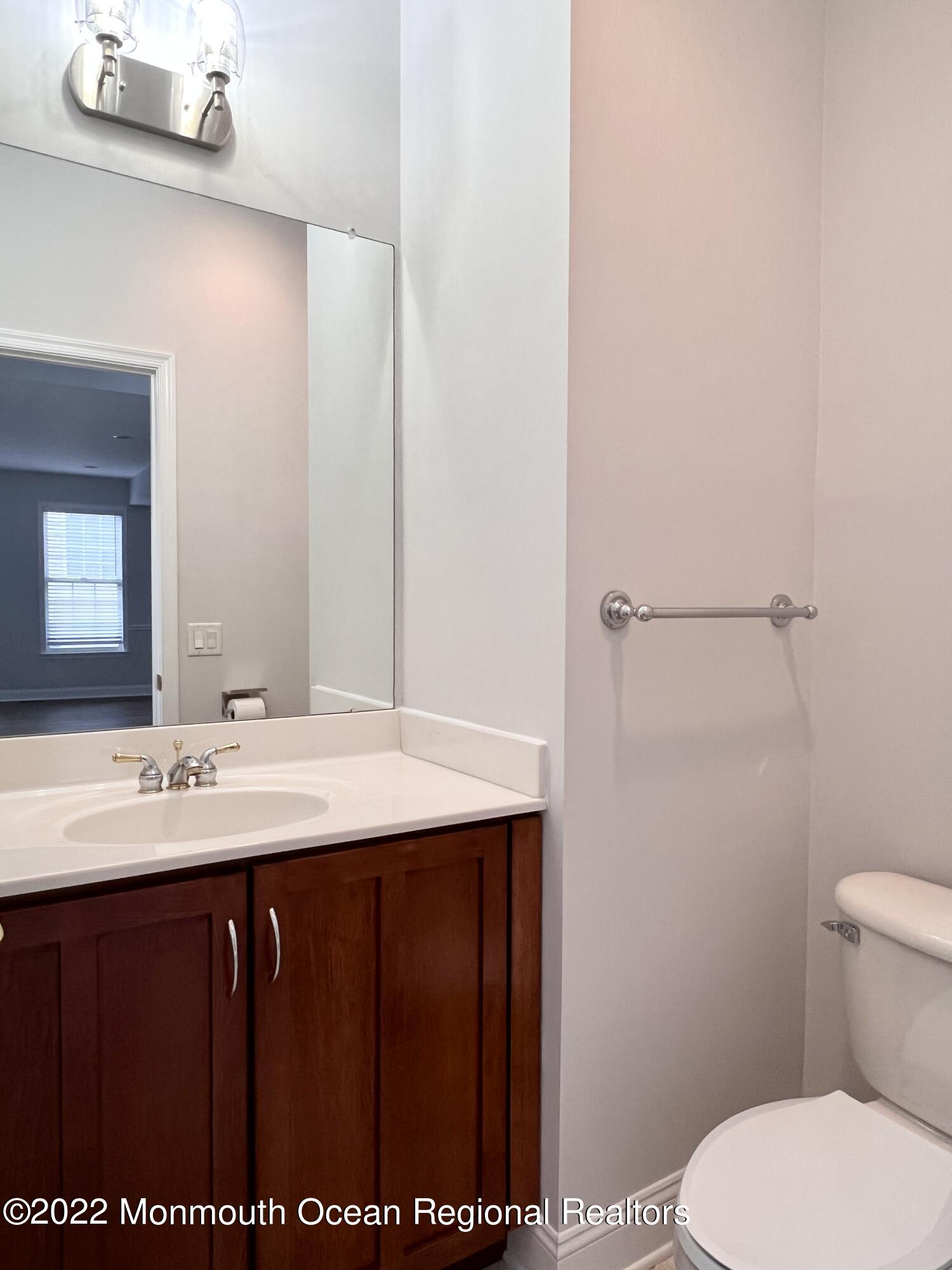 1 Hendrickson Court Manalapan, NJ 07726 - Photo 37 of 39 a bathroom with a sink a toilet and mirror