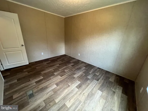 a view of empty room with wooden floor and cabinet
