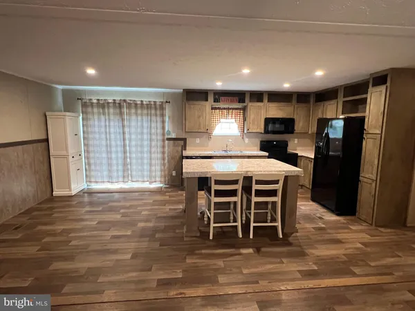 a kitchen with stainless steel appliances kitchen island granite countertop a refrigerator a stove a sink dishwasher with a dining table and chair