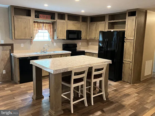 a kitchen with a wooden floor and a refrigerator