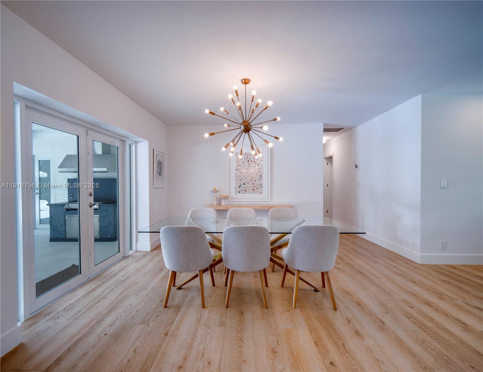 11905 Southwest 67th Avenue Pinecrest, FL 33156 - Photo 11 of 33 a dining room with furniture a chandelier and wooden floor