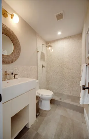 a bathroom with a sink a toilet and a mirror