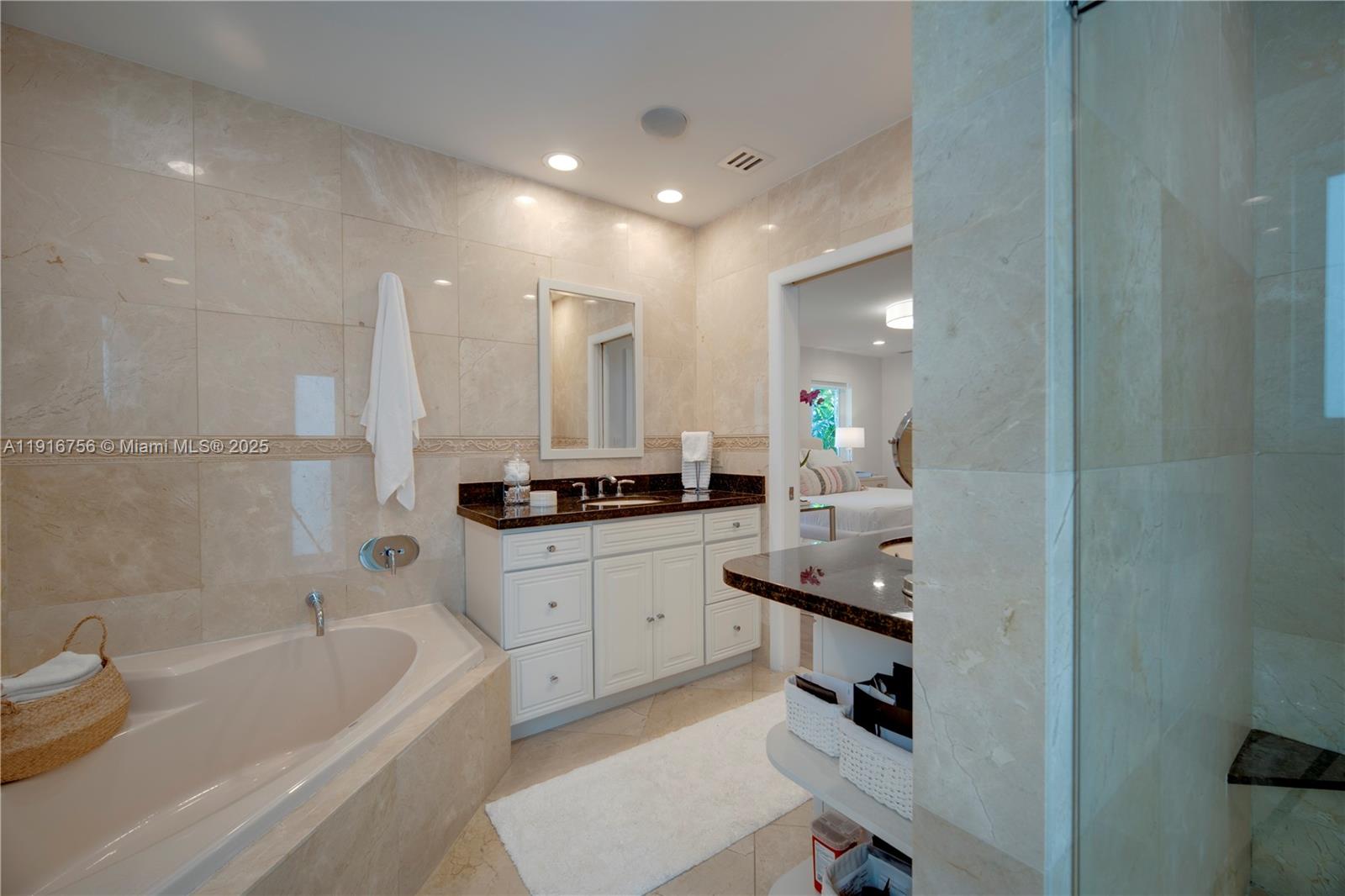 11905 Southwest 67th Avenue Pinecrest, FL 33156 - Photo 27 of 33 a bathroom with a bathtub a sink a vanity and shower