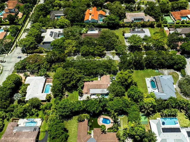 an aerial view of a house with a yard and lake view