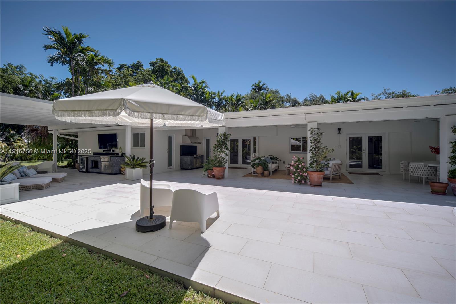 11905 Southwest 67th Avenue Pinecrest, FL 33156 - Photo 6 of 33 a front view of the house with yard and outdoor seating