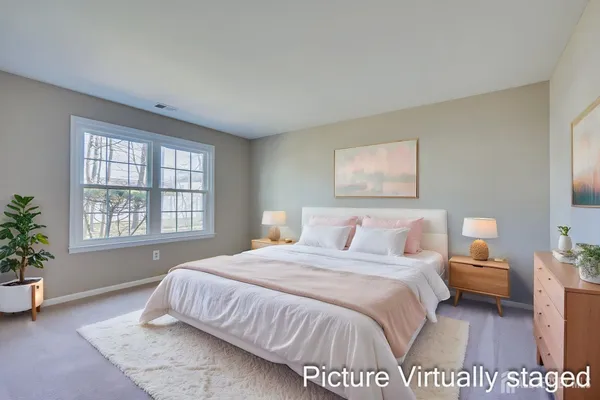 a spacious bedroom with a bed a couch and potted plant
