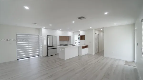 a view of a kitchen with a refrigerator and a stove top oven