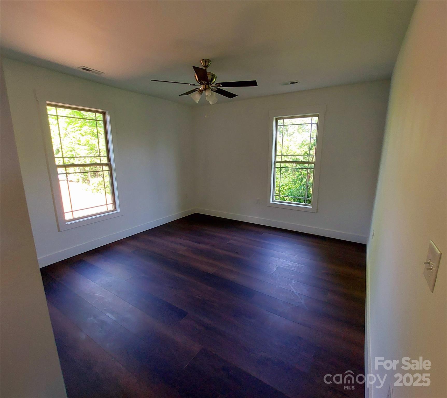 401 Constant Lane Columbus, NC 28722 - Photo 16 of 24 an empty room with wooden floor windows and fan