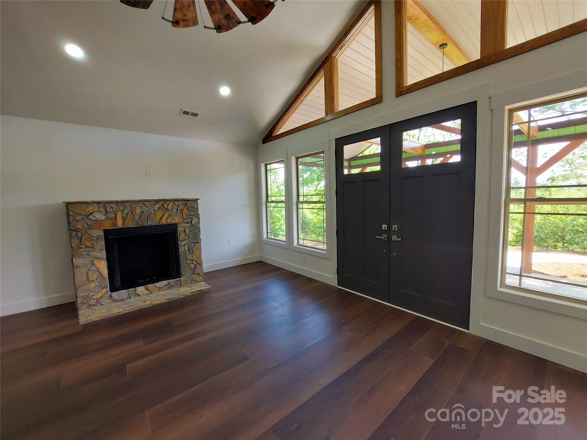 401 Constant Lane Columbus, NC 28722 - Photo 10 of 24 an empty room with wooden floor fireplace and windows