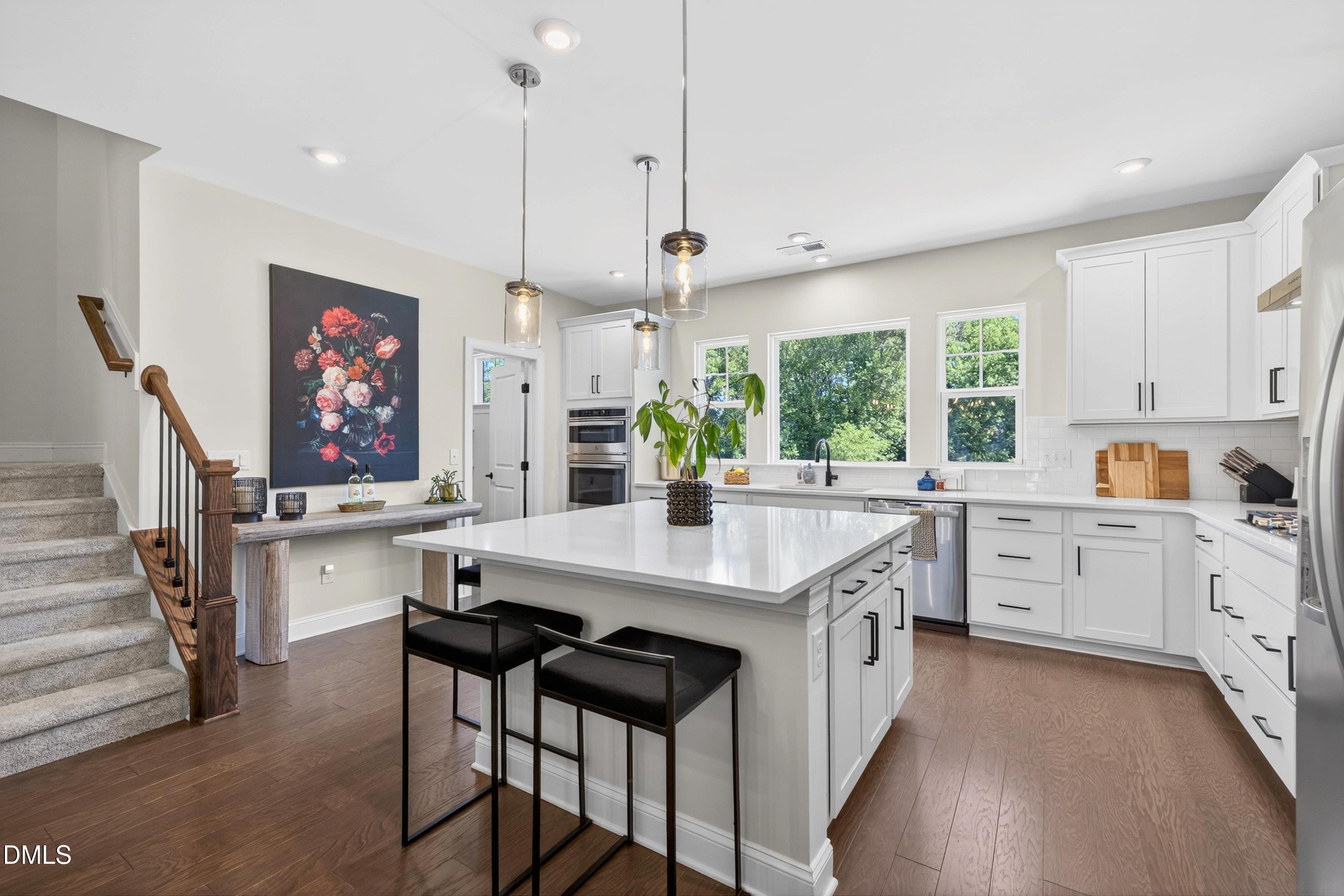 1063 Danvers Loop Apex, NC 27523 - Photo 20 of 67 a open kitchen with stainless steel appliances granite countertop a stove a sink dishwasher a refrigerator and a dining table with wooden floor