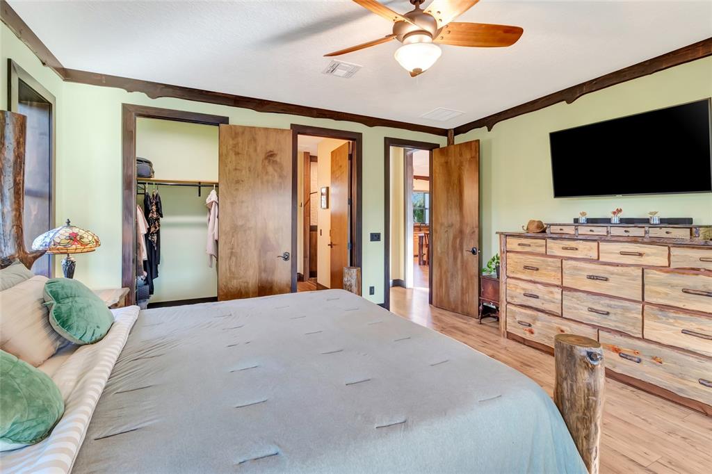 7330 Crabgrass Road St. Cloud, FL 34773 - Photo 23 of 60 a bedroom with a bed and a flat screen tv