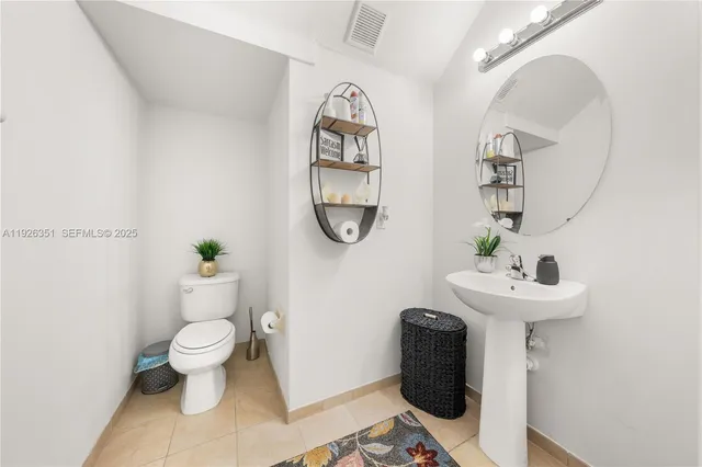 a bathroom with a sink toilet and a mirror