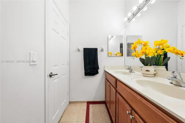 a bathroom with a sink and mirror with shower