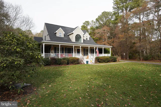 a front view of a house with a yard and trees