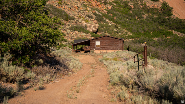 7500 Spring Canyon Road Helper, UT 84526 - Photo 4 of 64 Rustic cabin with wood-paneled exterior and covered porch