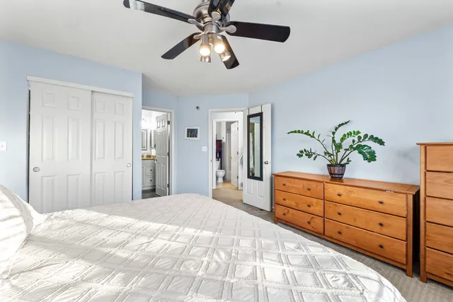 a spacious bedroom with a large bed and a chandelier
