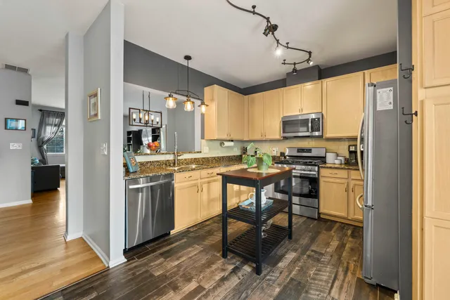 a kitchen with stainless steel appliances a stove a sink refrigerator and a microwave