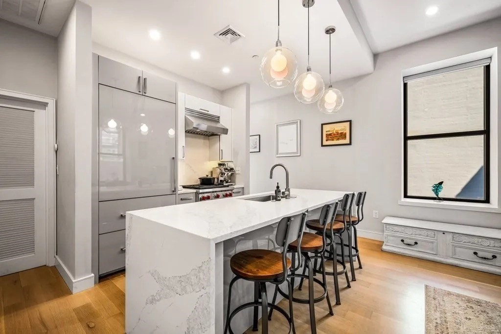 a kitchen with stainless steel appliances a table chairs and chandelier