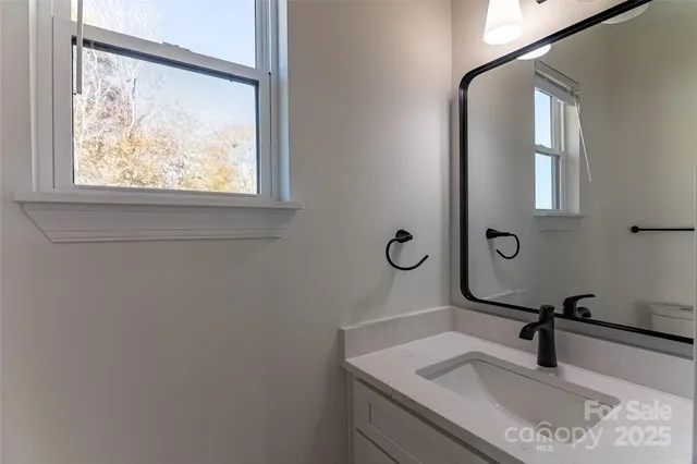 a bathroom with a granite countertop sink a mirror and a vanity