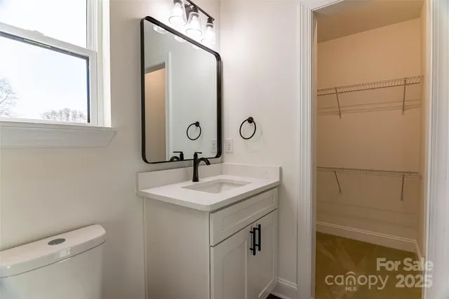 a bathroom with a sink and mirror with toilet