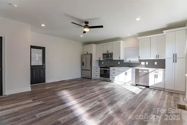 a view of kitchen with stainless steel appliances refrigerator stove microwave and cabinets