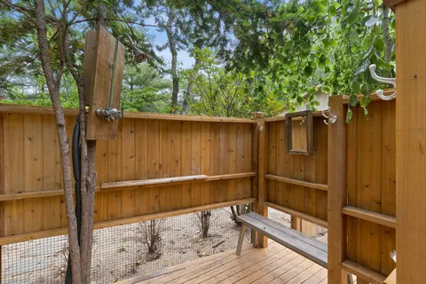 a backyard of a house with wooden floor and outdoor seating