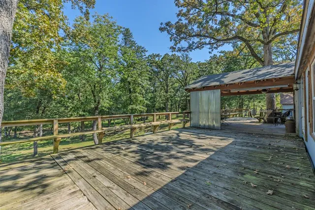 a view of a backyard with wooden floor and fence
