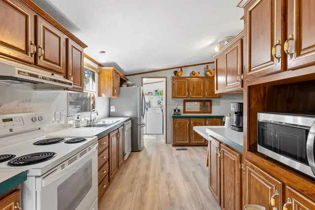 a kitchen with stainless steel appliances a stove a sink and a refrigerator