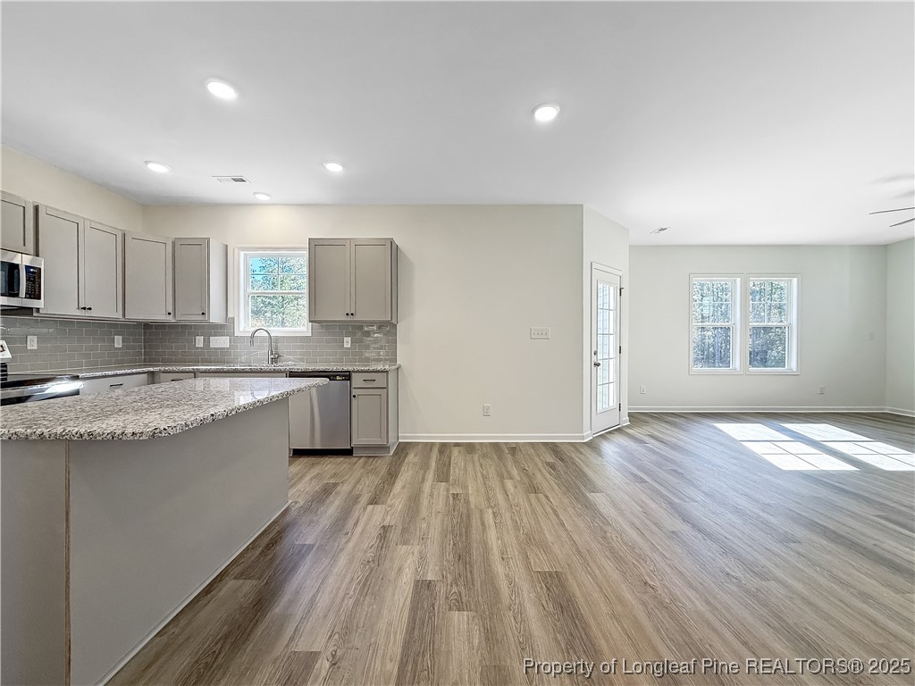 1020 Alex Baker (lot 9) Road Raeford, NC 28376 - Photo 11 of 31 a large kitchen with granite countertop a large counter top a sink stainless steel appliances and cabinets
