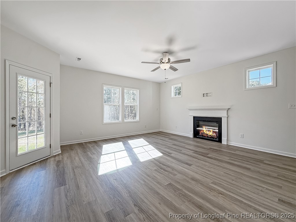 1020 Alex Baker (lot 9) Road Raeford, NC 28376 - Photo 15 of 31 an empty room with windows fireplace and wooden floor