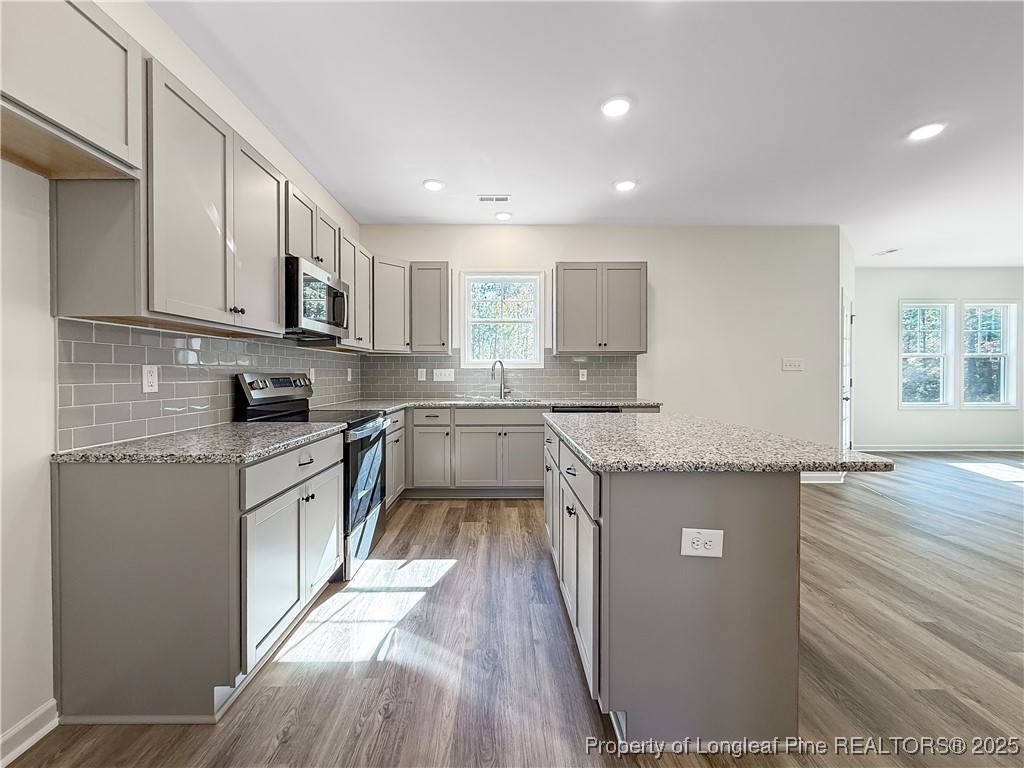 1020 Alex Baker (lot 9) Road Raeford, NC 28376 - Photo 7 of 31 a kitchen with kitchen island granite countertop a sink cabinets and wooden floor