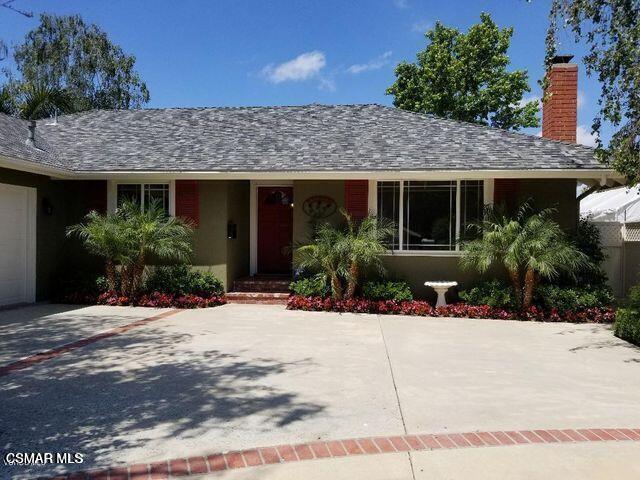 a view of a house with a yard and potted plants