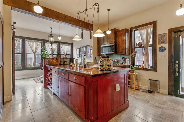 a kitchen with stainless steel appliances granite countertop a stove a sink a oven and a dining table with wooden floor