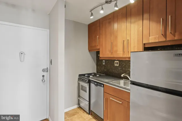 a kitchen with stainless steel appliances granite countertop a refrigerator and a stove