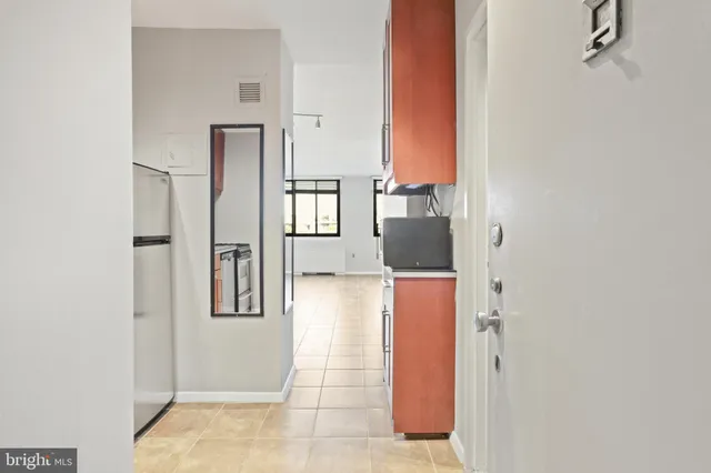 a view of a refrigerator a mirror on the wall