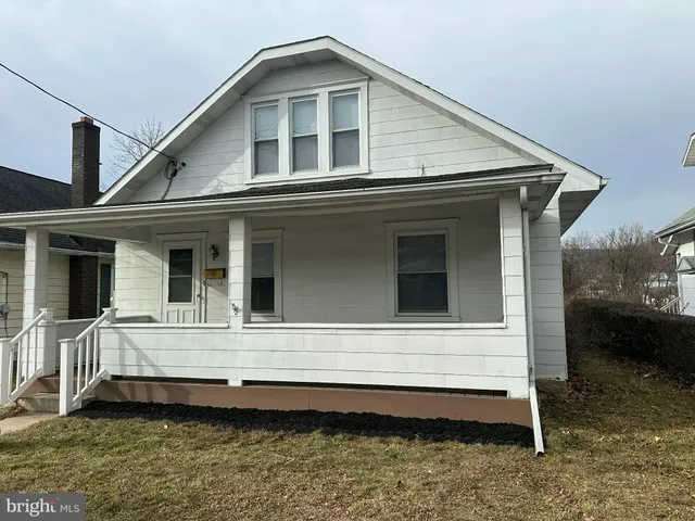 a view of a house with a yard and sitting area
