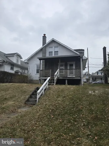 a view of an empty room with wooden floor and a ceiling fan