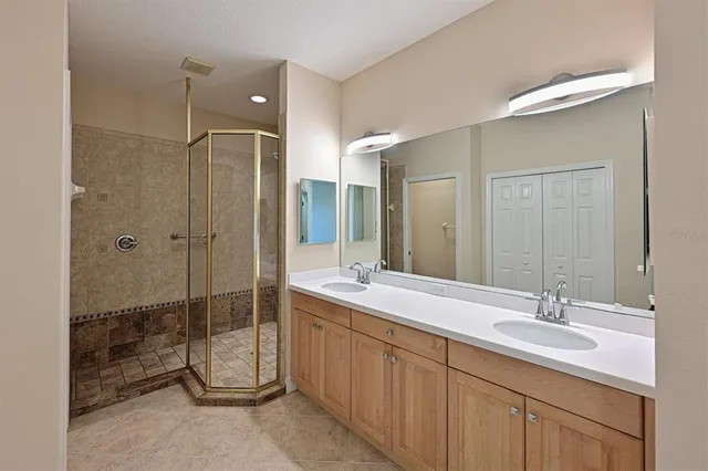 a bathroom with a double vanity sink mirror and shower