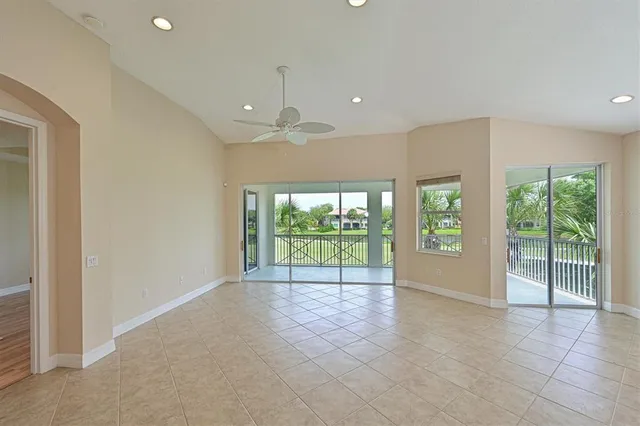 a view of an empty room with wooden floor and glass door