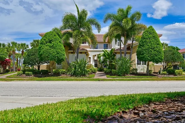 a front view of a house with a yard and trees